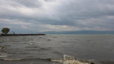 Almanya 'nın Langenargen kenti yakınlarındaki Constance Gölü' nü (Bodensee) dramatik bir fırtına sardı. Kara, kara kara bulutlar, dalgalı gri suların üzerinde sarkıyor, beyaz dalgaların kıyıya çarptığı yerde.
