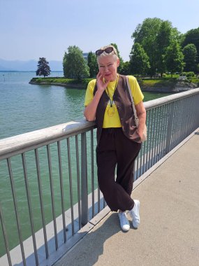 Turizm içeriği illüstrasyonu. Bodensee 'deki köprü manzarası çok güzel. Almanya, Lindau 'da olgun bir kadının tatili