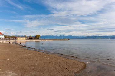 Almanya 'nın Langenargen kentinin kumlu ve çakıllı kıyılarından geniş ve sakin bir Constance Gölü manzarası uzanır.