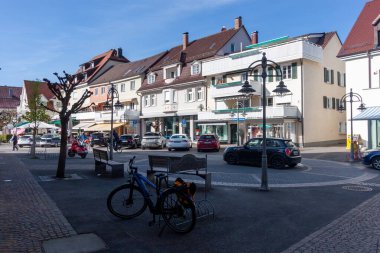 LANGENARJEN, GERMANY - 12 Nisan 2025: Canlı bir sokak sahnesi açık, güneşli bir günde Almanya 'nın Langenargen kentinin büyüleyici ana caddesini yakalıyor