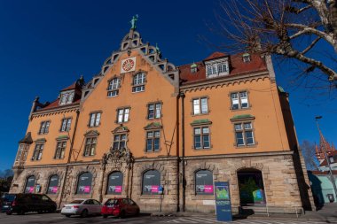 LINDAU, GERMANY - 26 Ocak 2025: Lindau, Almanya 'da sıcak turuncu cephesi ve karmaşık mimari ayrıntılarıyla karakterize edilen büyük, tarihi bir bina