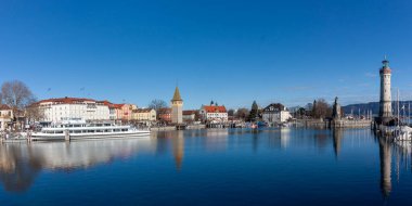 LINDAU, GERMANY - 26 HAZİRAN 2025: Lindau Gölü 'nün Constance Gölü üzerindeki panoramik manzarası, açık, parlak mavi bir gökyüzü altında