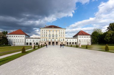 Münih, Almanya 'daki ikonik Nymphenburg Sarayı' nın muhteşem, geniş açılı manzarası dramatik bulutlu gökyüzü ve parlak güneş ışığının karışımı ile yıkandı.