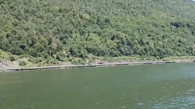 İsviçre 'deki Lucerne Gölü' nün (Vierwaldstttersee) göz kamaştırıcı panoramik manzarası, canlı, mavi bir gökyüzü altında, tüylü beyaz bulutlarla kaplı.