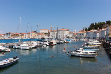 PİRAN, SLOVENIA - 19 Mayıs 2025: Adriyatik Denizi 'nin açık mavi sularına demirlemiş renkli tekneleri gösteren, Slovenya' nın Piran kentindeki güneşli ve canlı bir liman manzarası
