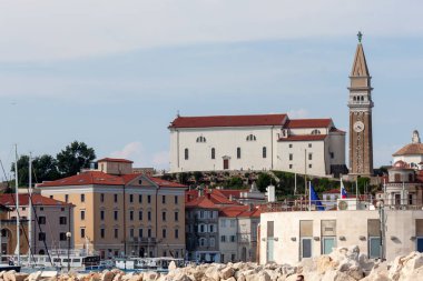 Parlak, berrak bir gökyüzü altında ikonik simgelerinin hakim olduğu Slovenya 'nın Piran kentinin çarpıcı siluetini uzun vadeli bir çekim yakaladı.