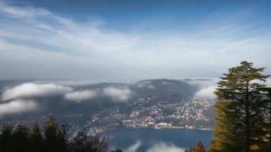 Como Gölü 'nün yukarısında nefes kesici panoramik manzara, Brunate' nin resimli köyünün kısmen yumuşak ruhani bulutlarla örtülmüş olduğunu gösteriyor.
