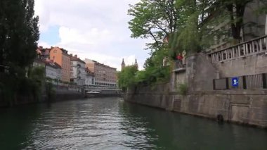 LJUBLJANA, SLOVENIA - 21 Mayıs 2025: Güzel bir günde Ljubljana, Slovenya 'daki sakin Ljubljanica Nehri boyunca sakin bir tekne gezisi