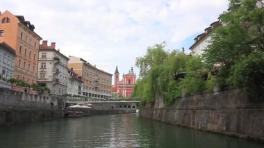 LJUBLJANA, SLOVENIA - 21 Mayıs 2025: Güzel bir günde Ljubljana, Slovenya 'daki sakin Ljubljanica Nehri boyunca sakin bir tekne gezisi