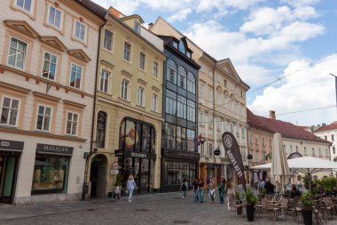 LJUBLJANA, SLOVENIA - 21 Mayıs 2025: Ljubljana, Slovenya 'nın büyüleyici mimarisini ve hareketli atmosferini gösteren canlı bir sokak manzarası