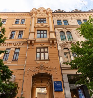 LJUBLJANA, SLOVENIA - 21 Mayıs 2025: Ljubljana, Slovenya 'daki geleneksel Avrupa mimarisinin çarpıcı düşük açılı görüntüsü, bitişik iki binanın ayrıntılı cephelerini gözler önüne seriyor