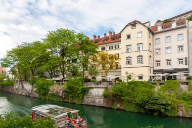 LJUBLJANA, SLOVENIA - 21 Mayıs 2025: Ljubljana, Slovenya 'daki sakin Ljubljanica Nehri boyunca manzaralı bir manzara, kentin büyüleyici nehir manzarasını gözler önüne seriyor