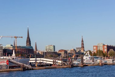 HAMBURG, GERMANY - 12 AĞUSTOS 2024: Hamburg, Almanya kıyı şeridinin panoramik bir görüntüsü, modern yüksek binalar ve klasik mimari tarzlarla dolu bir şehir silueti sergiliyor