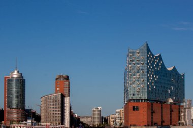 HAMBURG, GERMANY - 12 AĞUSTOS 2024: Hamburg, Almanya 'da parlak mavi gökyüzünün altında etkileyici bir modern mimari silueti