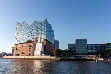 HAMBURG, GERMANY - 12 AĞUSTOS 2024: Modern Elbphilharmonie konser salonu Hamburg 'daki Elbe nehrinde belirgin bir şekilde duruyor.