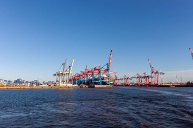 HAMBURG, GERMANY - 12 AĞUSTOS 2024 Hamburg 'un hareketli konteynır limanının geniş bir panoramik görüntüsü, liman boyunca sayısız kırmızı ve mavi vinç ve konteynır yığınları sergilenmektedir.
