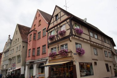 MEMINJEN, GERMANY - 20 AĞUSTOS 2025: Almanya 'nın Memmingen kentindeki bir cadde, pembe bir bina ve yarı keresteli bir bina da dahil olmak üzere çeşitli renklerde geleneksel gabayt binalarıyla çevrili.