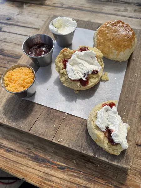 Yarısı yenmiş çilek reçelli, kremalı ve peynirli, restoranlı çörek.  