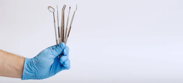Männerhand Blauem Handschuh Mit Zahnwerkzeug Auf Weißem Grund — Stockfoto