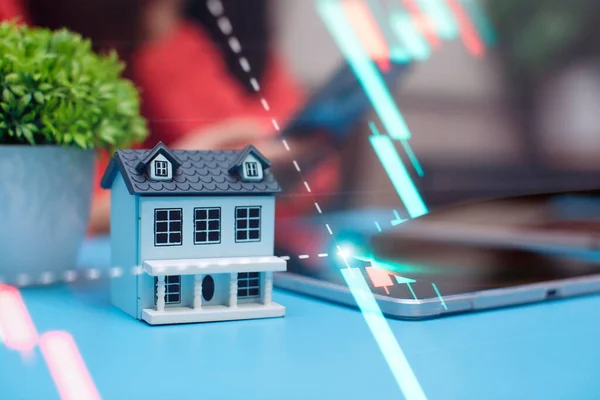 Häusermodell Vor Dem Hintergrund Der Börse Das Konzept Des Hauskaufs lizenzfreie Stockbilder