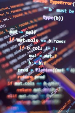 Bilgisayar veri programlaması çalıştırılıyor. Senaryo metni ekranda kodlanıyor. Not defteri yakın plan fotoğraf.