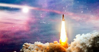 Roketler yıldızlı gökyüzünde uzaya fırlatılıyor. Uzay aracı duman bulutlarıyla uzaya uçar..