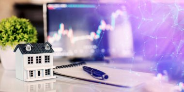 Ev modeli, kalem ve not defteri. Borsa tablosu, emlak piyasası, yatırım ticareti.