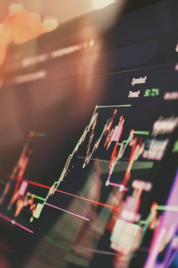 Renkli göstergeler ve pazar eğilimi verileriyle canlı bir şamdan grafiğini gösteren bir finans ticaret ekranının dinamik yakın çekimi.