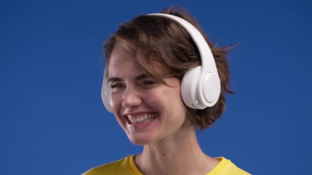 Šťastná Žena Poslouchající Hudbu Užívající Tanec Sluchátky Pozadí Modrého Studia — Stock video