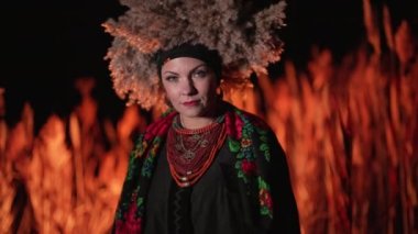 Geceleri geleneksel kamış kostümlü Ukraynalı etnik kadın. Kafasında çelenk olan gizemli kız. Ukrayna 'nın güzelliği, ayrıntılar, mücevherler, tarz kavramı. Yüksek kalite 4k görüntü