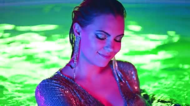 在霓虹灯下 性感迷人的女人在游泳池里跳舞 派对在俱乐部 迷人的别致在续集服装享受夜晚 奢华的生活 奢华的生活 高质量的4K镜头 — 图库视频影像