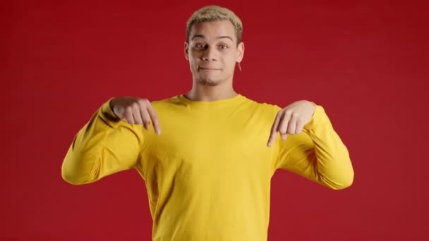Hombre Sonriente Apuntando Hacia Área Publicidad Fondo Rojo Adolescente Joven — Vídeos de Stock