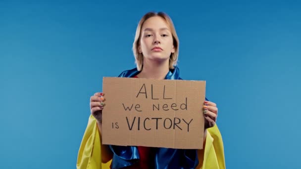 拥有硬纸板的乌克兰女人我们需要的只是蓝色背景的胜利 乌克兰将赢得战争 俄罗斯的凝聚概念 高质量的4K镜头 — 图库视频影像