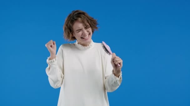 Mulher Cantando Dançando Com Escova Cabelo Vez Microfone Fundo Azul — Vídeo de Stock