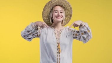Ukraynalı bir kadın reklam alanını işaret ediyor. Sarı arka plan. Genç bayan aşağıya üye olmak için tıklamak istiyor. Ticari fikrin için yer kopyala, promosyon içeriği. Yüksek kalite 4k görüntü