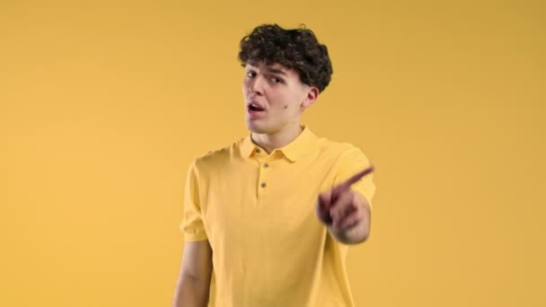 何のサインのジェスチャーもなく 興味のない男 同意しません 黄色の背景に若い男の肖像画 タイムアウトの概念 高品質4K映像 — ストック動画