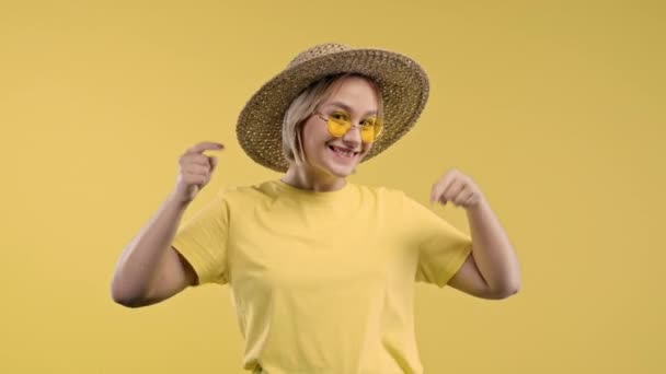 请点击下面订阅的年轻女士 复制空间为您的商业想法 促销内容 微笑的女人指着下面的广告区 黄色背景 高质量的4K镜头 — 图库视频影像