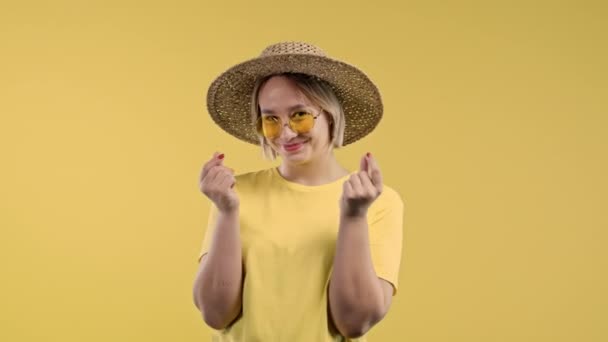 Wanita Muda Meminta Uang Isyarat Pada Latar Belakang Studio Kuning — Stok Video