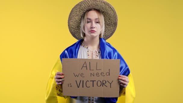 拥有硬纸板的乌克兰女人我们需要的只是黄色背景的胜利 乌克兰将赢得战争 俄罗斯的凝聚概念 高质量的4K镜头 — 图库视频影像
