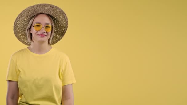 微笑的女士期待空地方为您的广告 建议妇女指向右侧 复制空间 女性在黄色背景下呈现孤立的东西 高质量的4K镜头 — 图库视频影像