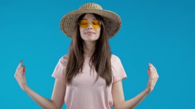 Sakin bir kadın dinleniyor, meditasyon yapıyor, stresi reddediyor. Güneşli Asyalı kız derin derin nefes alıyor, mavi stüdyo arka planını sakinleştiriyor. Yoga, ahlaki denge, zen konsepti. Yüksek kalite 4k görüntü