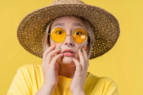 Frightened shocked woman afraid of something and looks into camera with big eyes full of horror on yellow background. Phobia, trouble, panic concept. High quality photo
