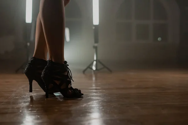 ランプ付きのスモーキーダンススタジオに立ってヒールの女性 セクシーな細い足の女の子 現代の振付家 女性の靴のコンセプト 高品質の写真 — ストック写真