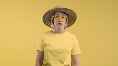 Sıkılmış üzgün kadın sarı arka planda iç çekiyor. Hoşnutsuzluk içindeki güzel bayan, durumdan bıkmış, boş vaatler, konuşmalar. Yüksek kalite 4k görüntü