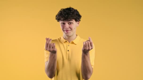 Mladý Muž Žádá Peníze Gesto Žlutém Pozadí Studia Chytrý Chlap — Stock video