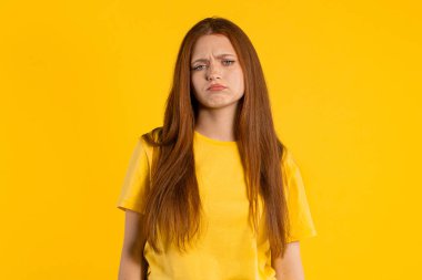 Hayal kırıklığına uğramış kızıl kadın hayal kırıklığına uğramış, hayal kırıklığına uğramış. Sarı stüdyo geçmişi. Hüzünlü somurtma, depresyon, olumsuz. Yüksek kalite fotoğraf