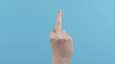 Expression negative, aggression, provocation. Rude woman on blue background showing middle finger - gesture of fuck. High quality 4k footage