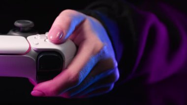 Kumanda panelinde joystick ile video simülatörü oynayan bir kadın, neonlu karanlık bir oda. Oyun konsolu olan bir oyuncu, en yeni kablosuz oyun alanı. Hobi, e-spor. - Boş zaman. Yüksek kalite 4k görüntü