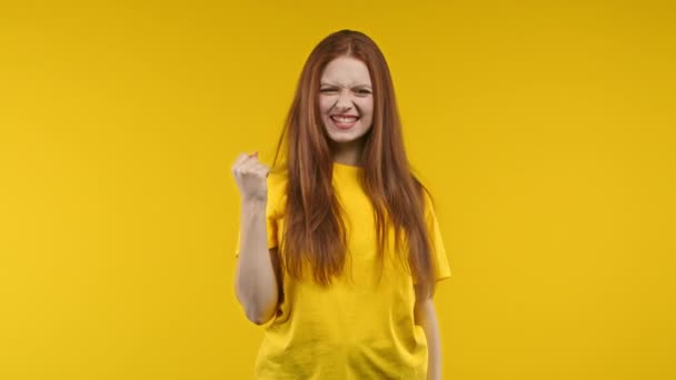 かなりの女性は勝利はいはい勝利のジェスチャーを示し 結果を達成し 女の子 黄色の背景に興奮した幸せな女性を驚かせた 勝利の概念 高品質4K映像 — ストック動画