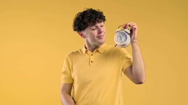 黄色の背景に目覚まし時計を持つ幸せな男 最終的に十分な睡眠の概念を得た 高品質4K映像 — ストック動画